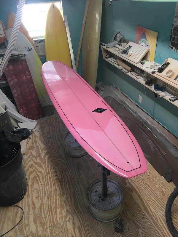 Custom mini-noserider longboard with pink resin tint. Made by Garbutt Surfboards